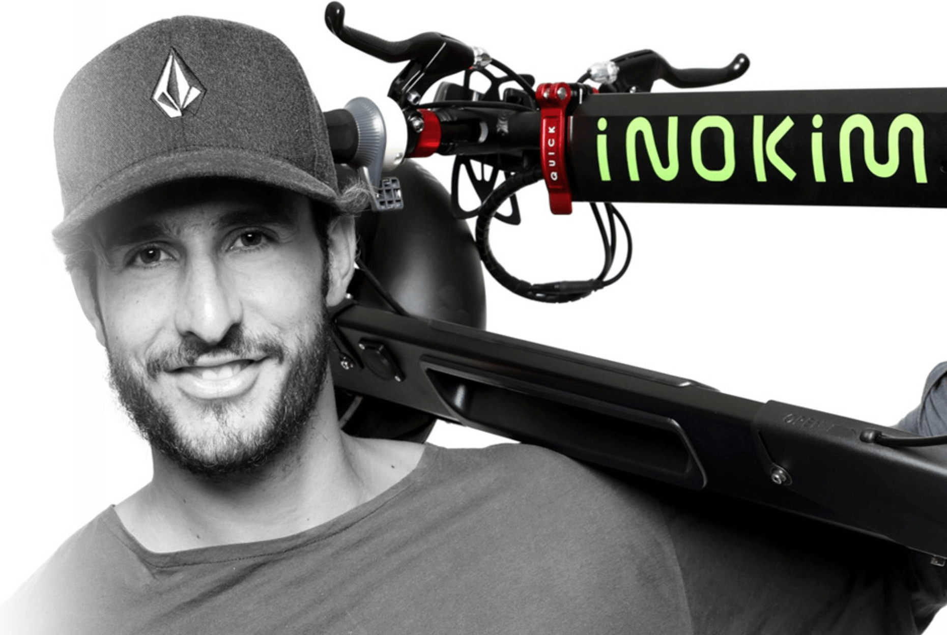 Man wearing cap holding a brand new Quick 3 electric kick scooter by Inokim in the folded position