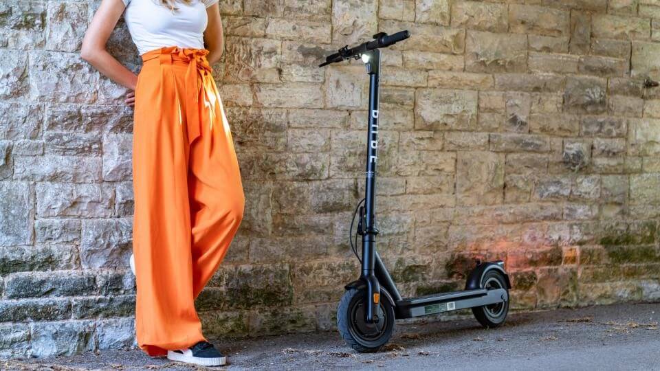 Attractive woman stood next to her Pure Air Pro electric scooter 2020