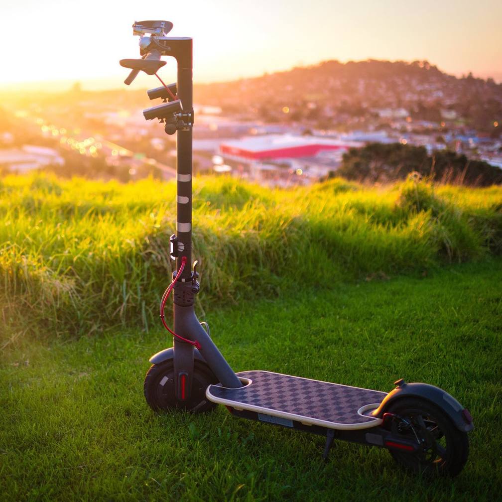 panorama image of the scooter parked on the grass overlooking the city