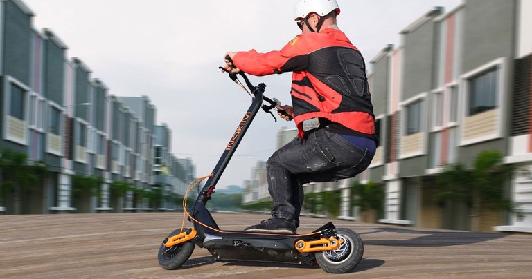 Man riding the Inokim Ox scooter quickly around a right corner